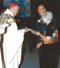photo of Bishop Bullock presenting Dr. Tom Lang and his wife, Peggy, with certificate