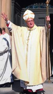 photo of Archbishop Timothy M. Dolan waving to those gathered outside cathedral