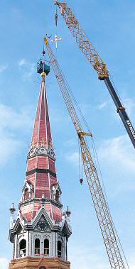 photo of cranes lifting cross to top of new spire on St. Raphael Cathedral in Madison