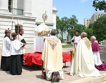 photo of Monsignor Holmes, Bishop Morlino and Bishop Swain kneeling before the Blessed Sacrament outside the state Capitol as part of the Corpus Christi procession on Sunday, June 10