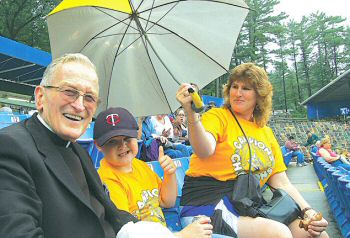 photo of Monsignor Thomas Campion, director of the Apostolate to the Handicapped, with Jacob Hawkinson and his mother Connie, at the Tommy Bartlett Water Show in the Wisconsin Dells