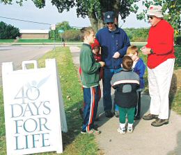 photo of Andy Galvin, left, and his sons joining Tom Delaney in praying the Rosary outside the Planned Parenthood Clinic as part of Madison's 40 Days for Life