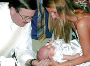 photo of transitional deacon Rev. Mr. Patrick Wendler baptizing Kaylee as her mother Molly holds her at St. Thomas Aquinas Parish in Madison